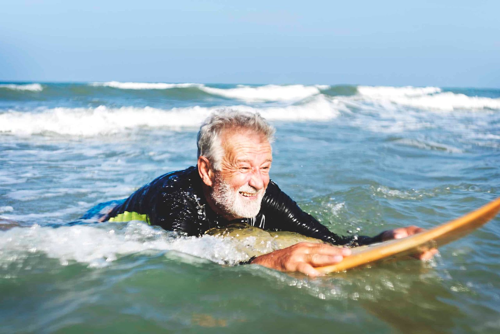 A senior man on a surfboard