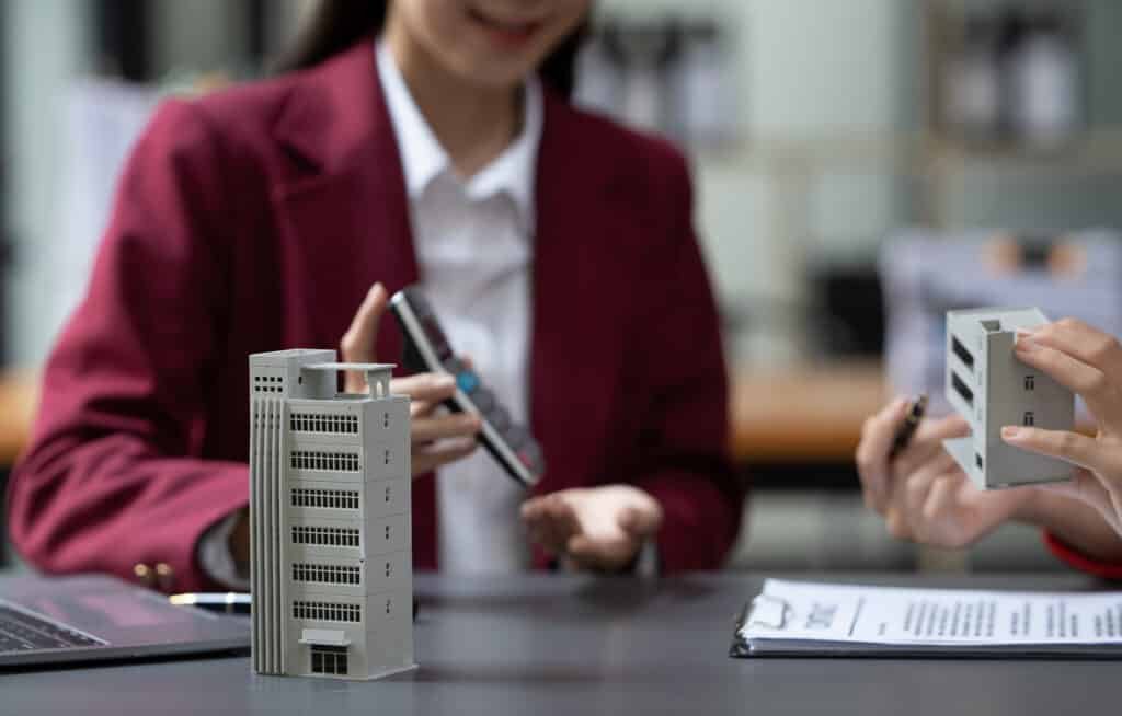 Asian businesswoman making a deal to buy a house or condo inside the office, home insurance concept