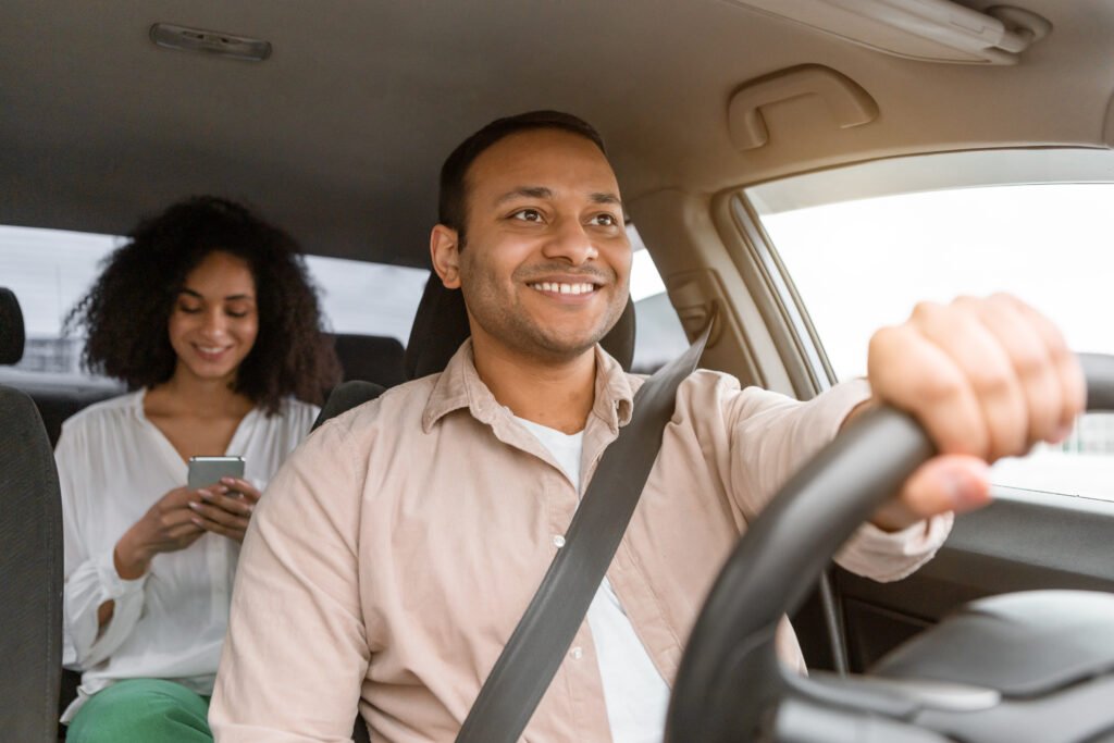 Taxi Driver Navigating Car While Passenger Using Smartphone On Backseat